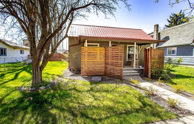 111 6th Ave W, Polson, MT 59860 - view of front of property featuring fence, a front yard, and metal roof