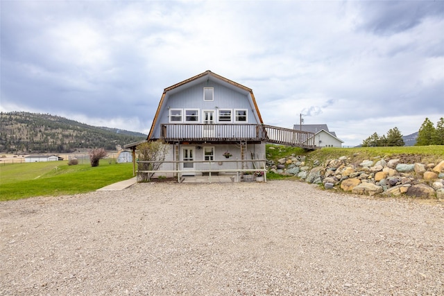 290 Browns Meadow Rd, Kila, MT 59920 - rear view of property featuring a lawn, a gambrel roof, and a deck