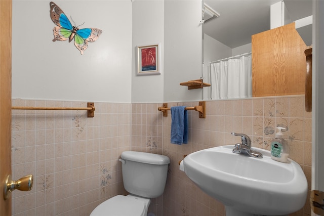 290 Browns Meadow Rd, Kila, MT 59920 - full bathroom featuring wainscoting, a sink, toilet, tile walls, and a shower with curtain