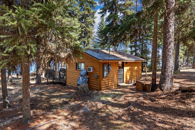back of property featuring metal roof and log veneer siding