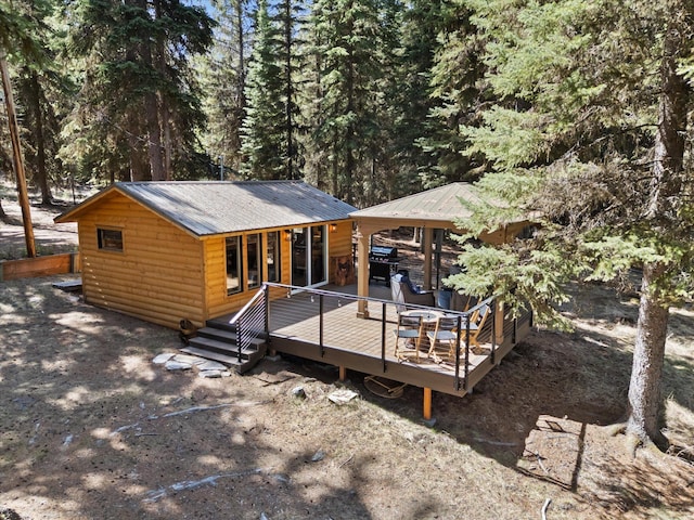 560 Mcgregor Ln, Marion, MT 59925 - rear view of property featuring log veneer siding, a deck, a view of trees, and metal roof