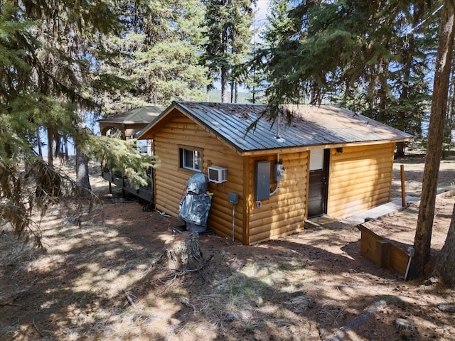view of outbuilding featuring an AC wall unit and an outdoor structure