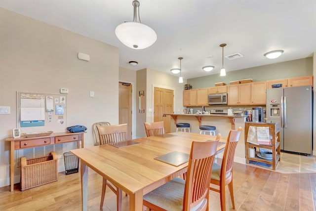 dining room featuring visible vents and light wood-style floors