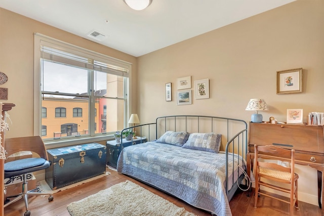 bedroom featuring wood finished floors and visible vents