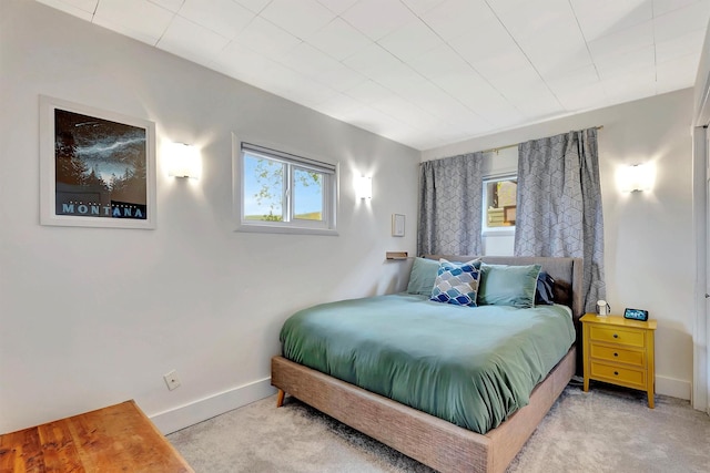 bedroom featuring baseboards, multiple windows, and carpet floors