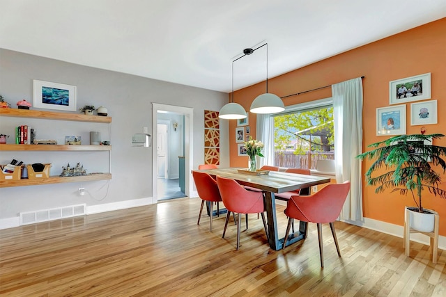 dining space featuring baseboards, light wood finished floors, and visible vents