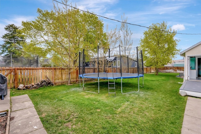 view of yard featuring a fenced backyard and a trampoline