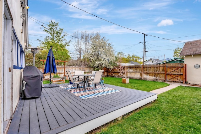 deck with a lawn, a fenced backyard, outdoor dining area, and area for grilling