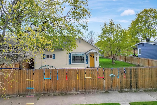 bungalow-style house with a gate, a fenced front yard, and stucco siding