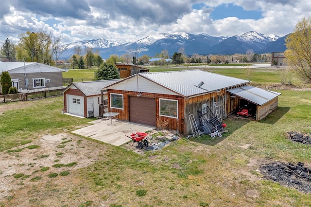 garage with a mountain view, driveway, and fence