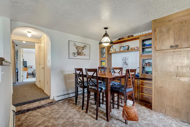 dining room featuring a textured ceiling, arched walkways, baseboard heating, a baseboard radiator, and carpet
