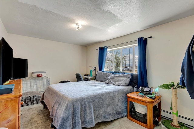 carpeted bedroom with a textured ceiling and a baseboard heating unit