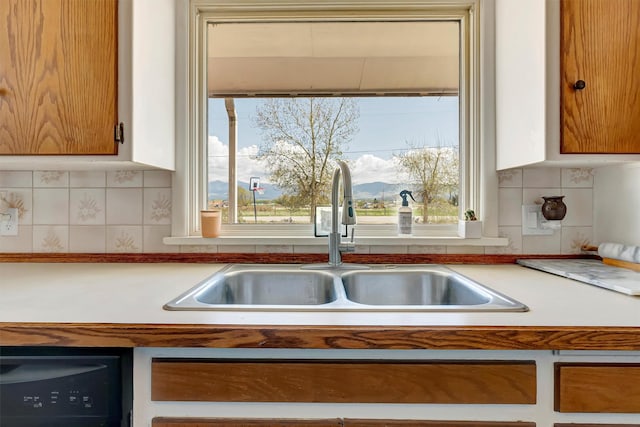 kitchen with a sink, light countertops, and tasteful backsplash
