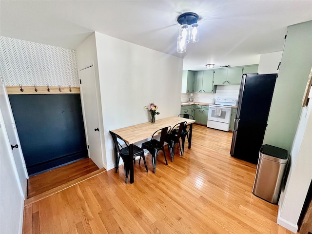 dining area featuring wallpapered walls and light wood-style floors