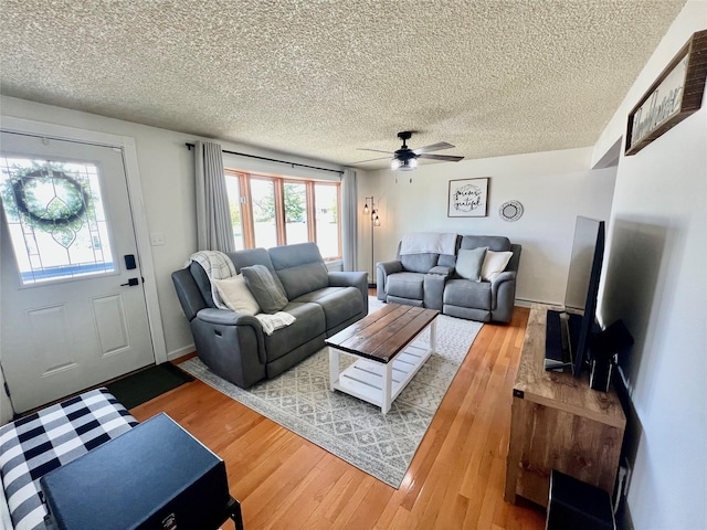 living area featuring a textured ceiling, ceiling fan, and wood finished floors