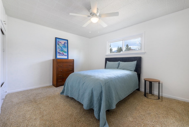 bedroom with baseboards, ceiling fan, and light carpet
