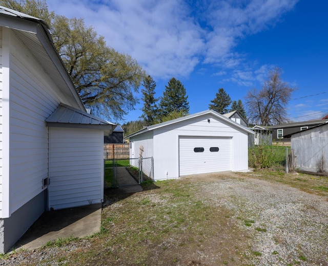 detached garage with fence and driveway