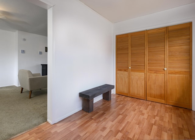 unfurnished bedroom featuring a closet, baseboards, and light wood-style floors