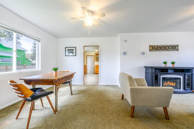 dining area with a glass covered fireplace, baseboards, ceiling fan, and carpet flooring