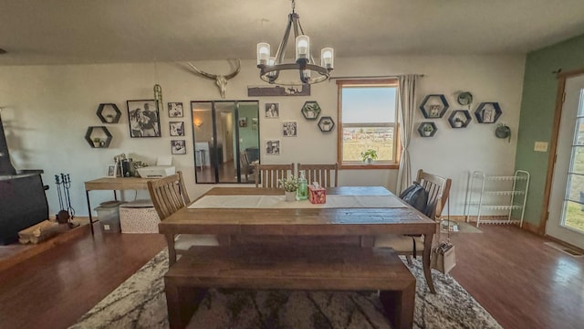 dining area featuring an inviting chandelier, baseboards, wood finished floors, and visible vents