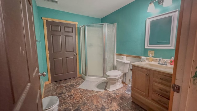 bathroom featuring vanity, a stall shower, and toilet