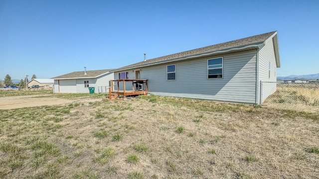 back of house featuring fence and a deck