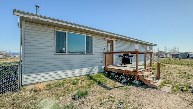 rear view of property with fence and a deck