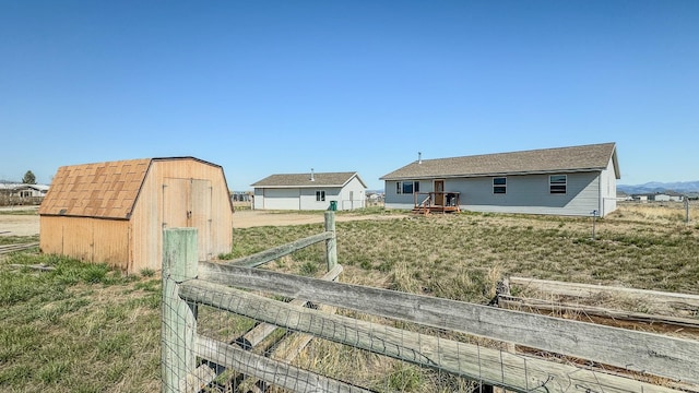 exterior space featuring a storage shed, fence, and an outbuilding