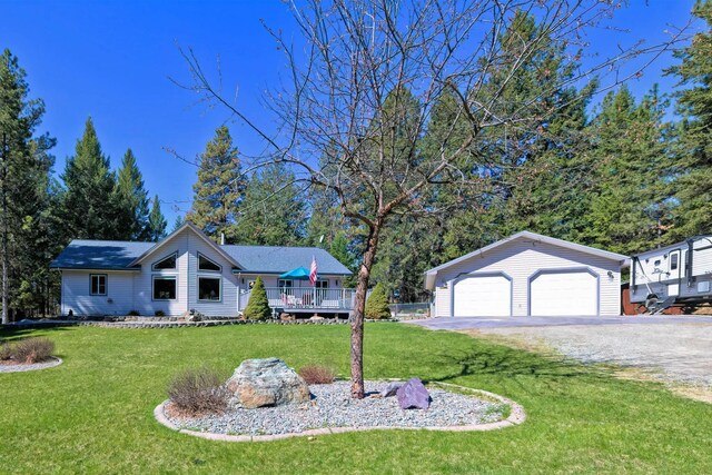 261 Green Briar Trl, Eureka, MT 59917 - view of front of house with a garage, an outbuilding, a deck, and a front lawn