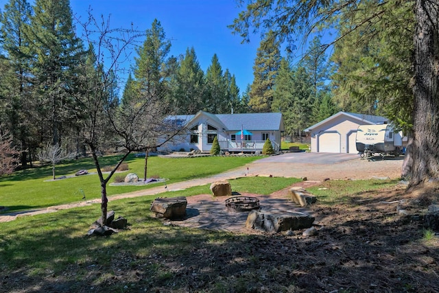 261 Green Briar Trl, Eureka, MT 59917 - view of front of home featuring an outdoor structure, an outdoor fire pit, driveway, and a front yard