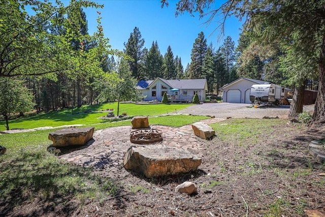 261 Green Briar Trl, Eureka, MT 59917 - view of yard featuring an outdoor structure, a fire pit, and driveway
