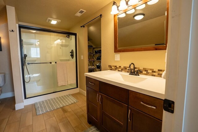 617 N 5th St, Hamilton, MT 59840 - bathroom featuring a textured wall, vanity, a walk in closet, and a textured ceiling