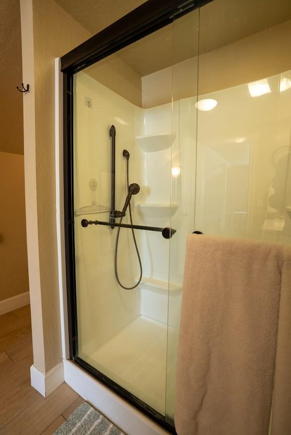 617 N 5th St, Hamilton, MT 59840 - bathroom with a stall shower, baseboards, and wood finished floors