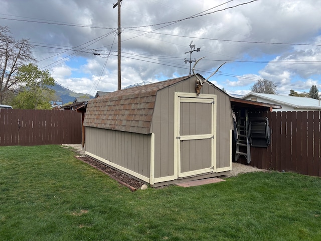 view of shed featuring fence and a mountain view