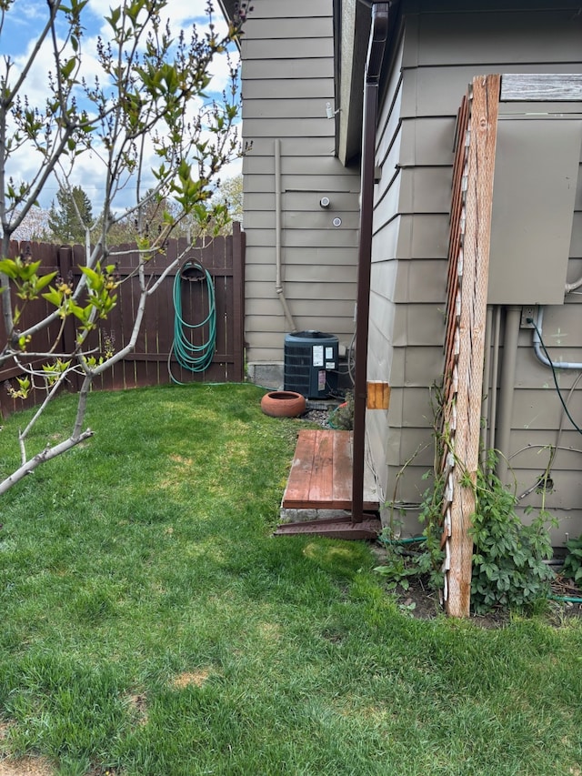 view of yard with central air condition unit and a fenced backyard