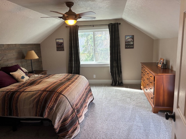 bedroom featuring lofted ceiling, baseboards, light colored carpet, a textured ceiling, and a ceiling fan