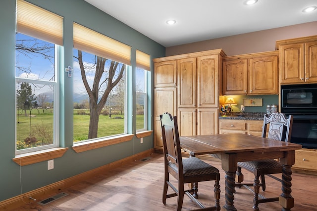 dining area featuring visible vents, light wood finished floors, and a healthy amount of sunlight