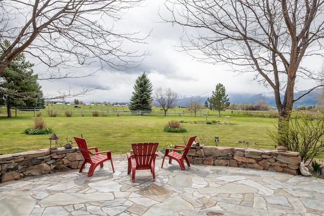 view of patio featuring a mountain view, fence, and a rural view
