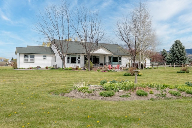 back of house featuring a yard and fence