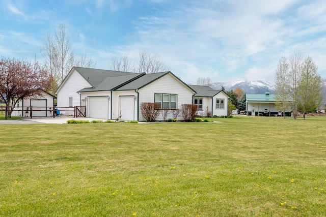 view of front of home with an outbuilding, an attached garage, concrete driveway, and a front lawn