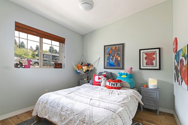 bedroom with baseboards and wood finished floors