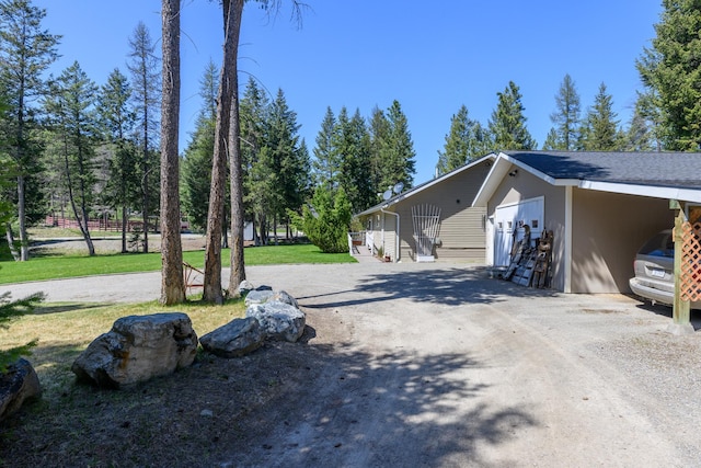 view of side of property featuring a lawn and driveway