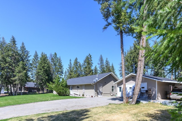 exterior space featuring a garage, a front lawn, and aphalt driveway