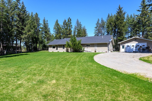 ranch-style home with a garage, an outbuilding, and a front yard