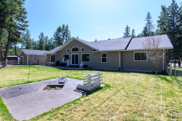back of house with a lawn, a patio, fence, and roof with shingles