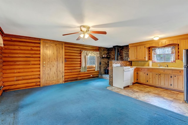 kitchen with white range, ceiling fan, plenty of natural light, and a wood stove
