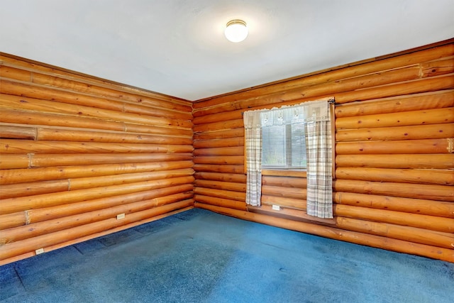 carpeted empty room featuring rustic walls