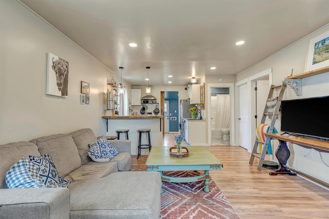 living room featuring recessed lighting, crown molding, and light wood finished floors