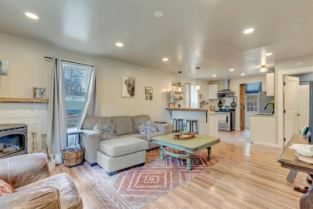 living room with light wood-type flooring and recessed lighting