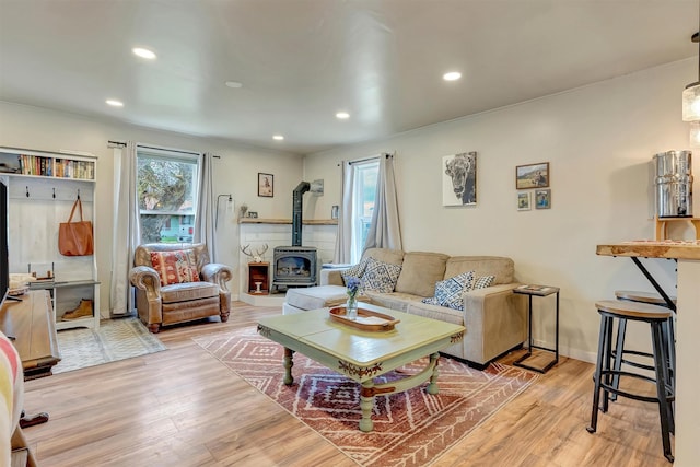 living room featuring recessed lighting, wood finished floors, and a wood stove